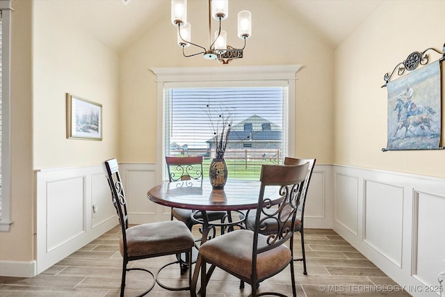 dining room featuring vaulted ceiling and a chandelier