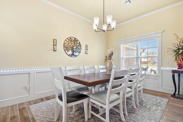 dining area featuring a chandelier and crown molding