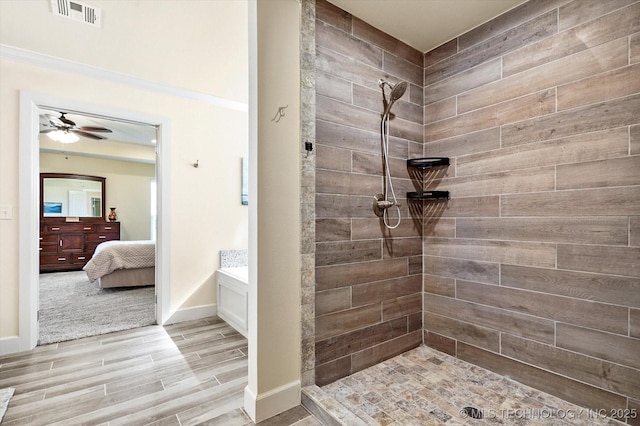 bathroom featuring hardwood / wood-style flooring, ceiling fan, ornamental molding, and tiled shower