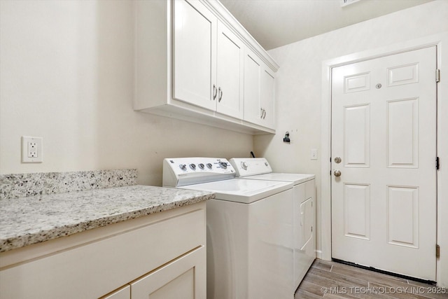 laundry room featuring washer and dryer and cabinets