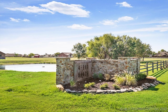 community / neighborhood sign with a yard and a water view