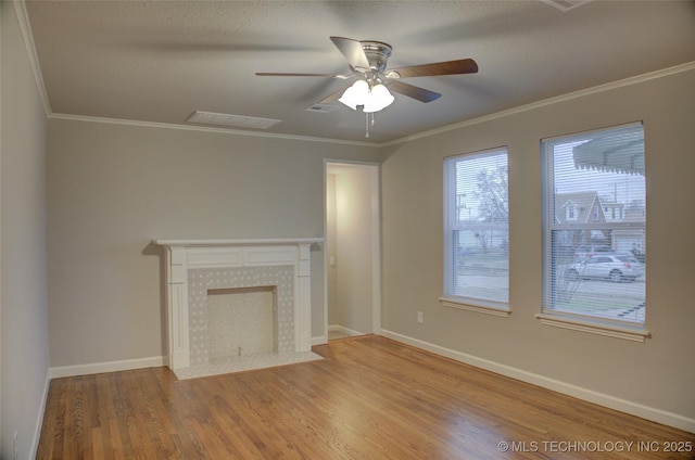 unfurnished living room featuring ornamental molding, a textured ceiling, ceiling fan, wood-type flooring, and a fireplace