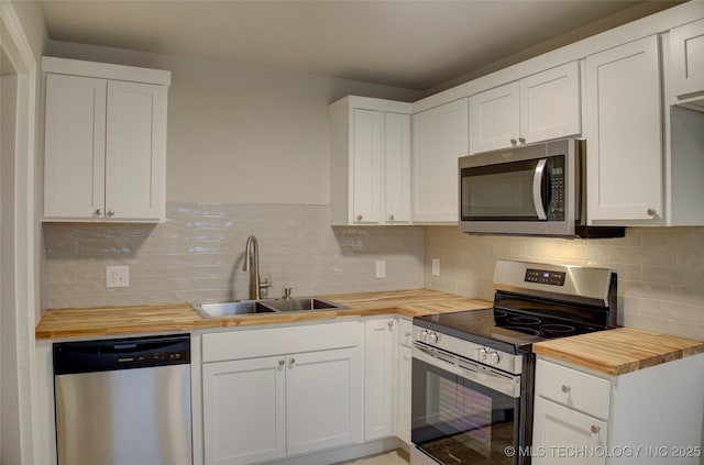 kitchen featuring white cabinets, wood counters, sink, and stainless steel appliances