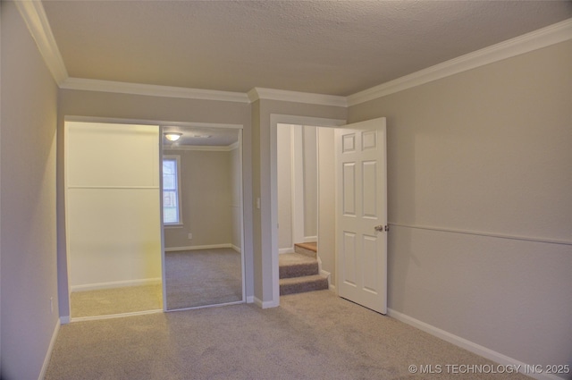 carpeted spare room featuring a textured ceiling and ornamental molding