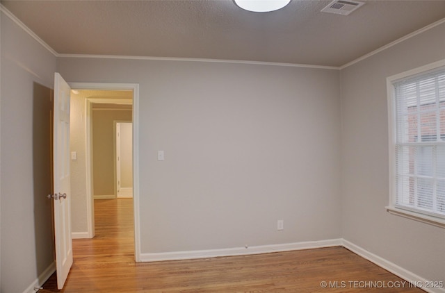 empty room featuring light hardwood / wood-style floors and crown molding