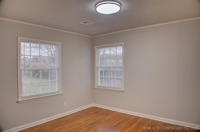 empty room with hardwood / wood-style flooring and ornamental molding