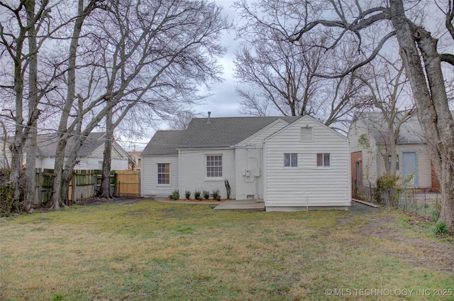 rear view of house featuring a lawn