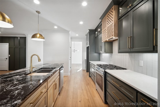 kitchen with sink, light hardwood / wood-style flooring, decorative light fixtures, appliances with stainless steel finishes, and ornamental molding