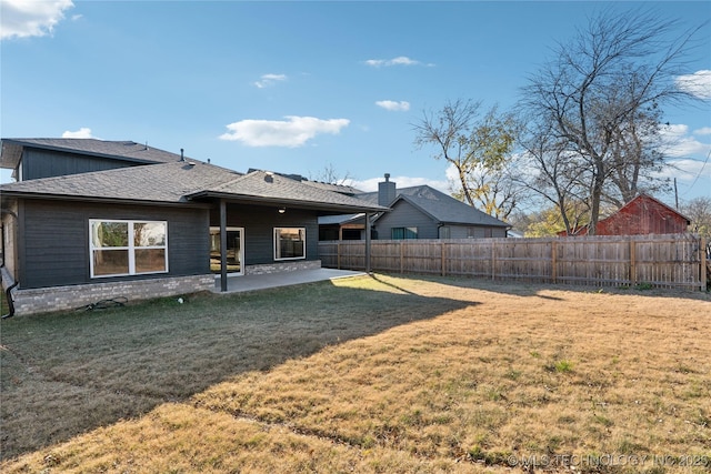 back of property with a lawn and a patio