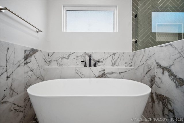 bathroom with a bathtub and tile walls