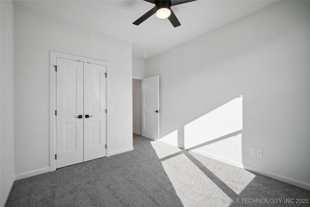 unfurnished bedroom featuring a closet, dark carpet, and ceiling fan