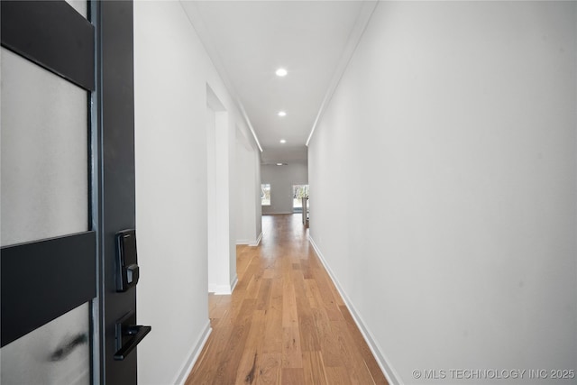 corridor featuring light hardwood / wood-style floors and crown molding