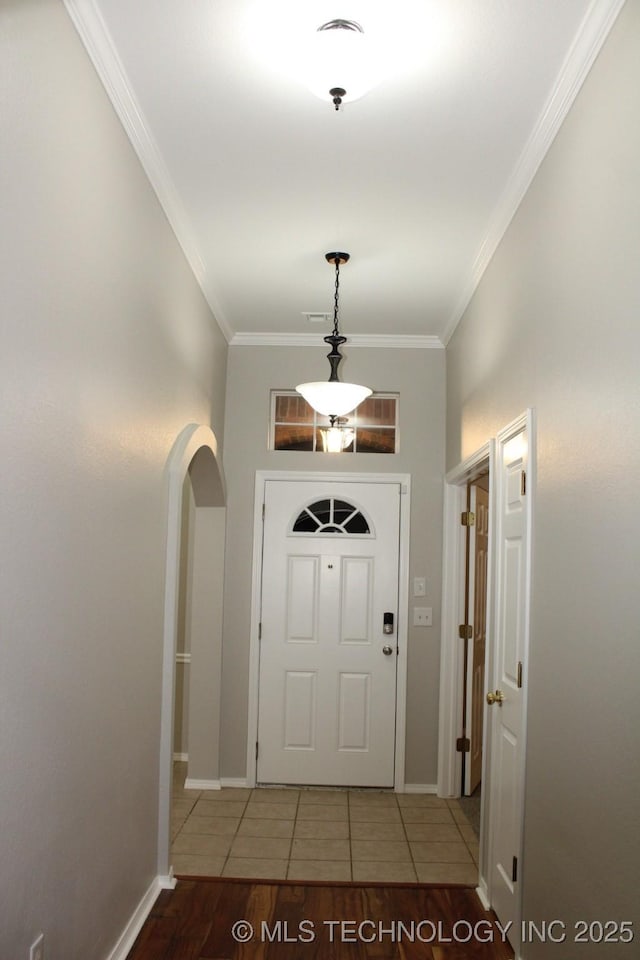 entryway featuring tile patterned flooring and ornamental molding