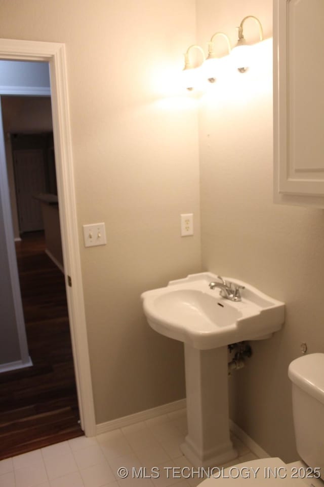 bathroom with tile patterned flooring, toilet, and sink