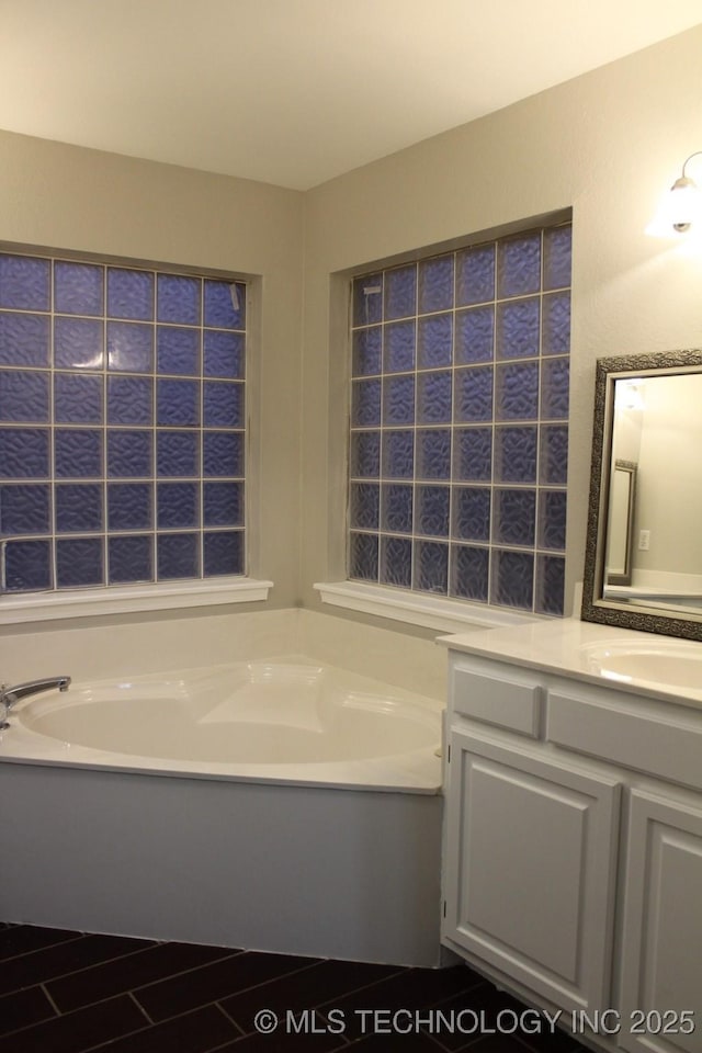 bathroom with a bathing tub and vanity