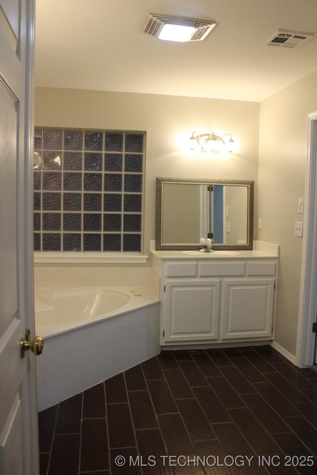 bathroom with a washtub and vanity