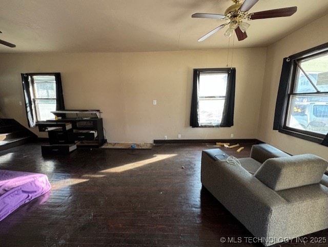 living room featuring ceiling fan and dark wood-type flooring