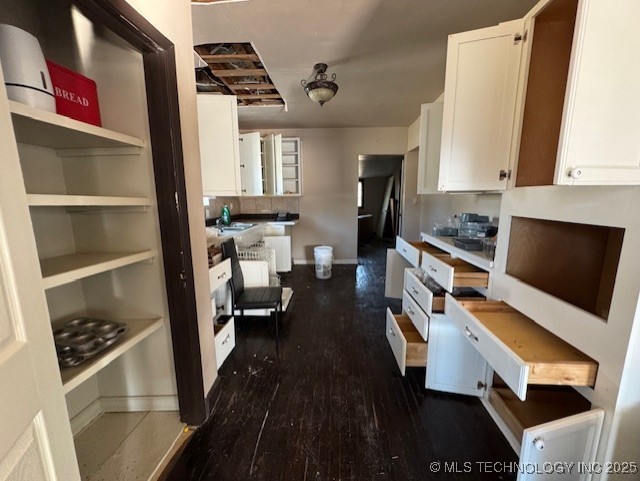 kitchen featuring dark hardwood / wood-style flooring, white cabinetry, and sink