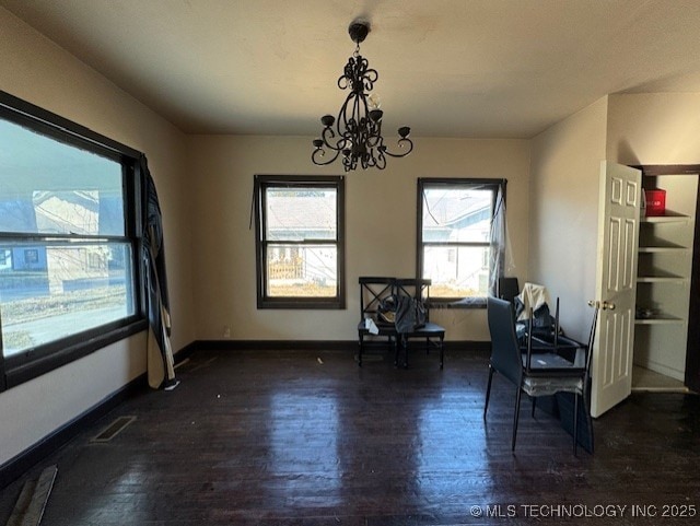 dining area with a notable chandelier and dark wood-type flooring