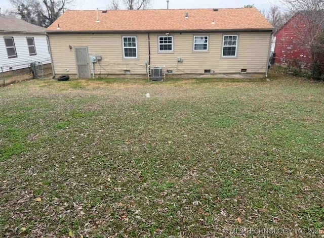 back of house featuring central air condition unit and a yard