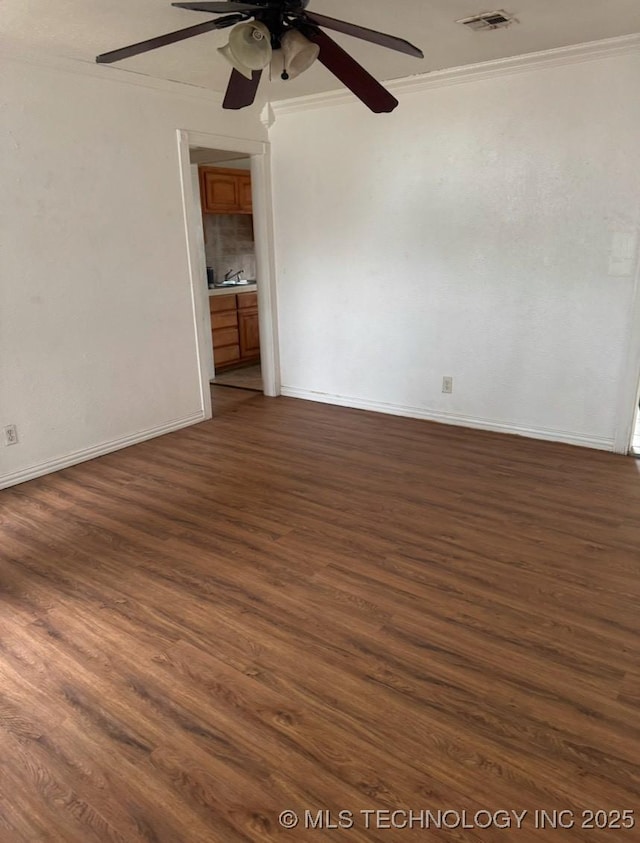 spare room featuring ceiling fan, dark hardwood / wood-style flooring, and ornamental molding