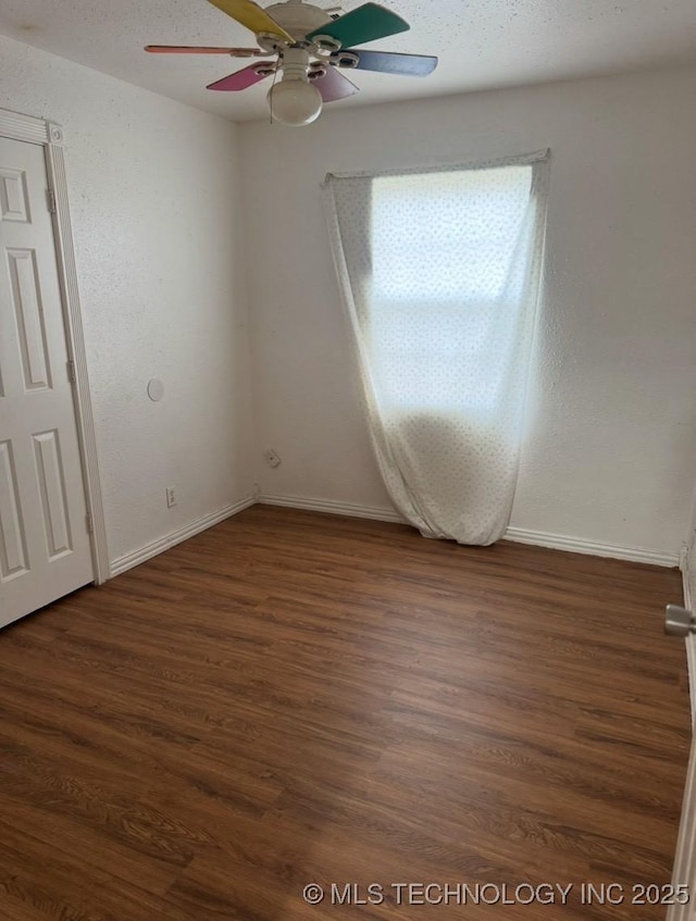 unfurnished room with ceiling fan and dark hardwood / wood-style flooring