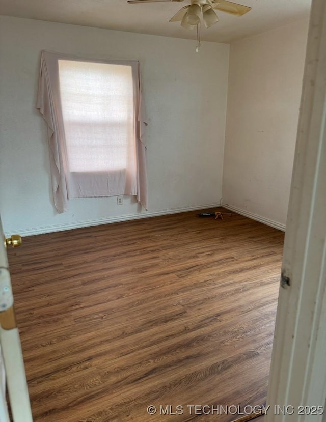 empty room with dark hardwood / wood-style floors and ceiling fan