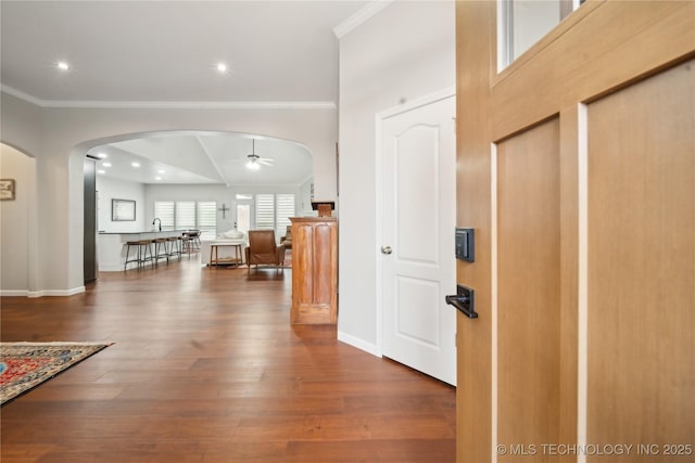 entrance foyer featuring ceiling fan, dark hardwood / wood-style flooring, crown molding, and vaulted ceiling