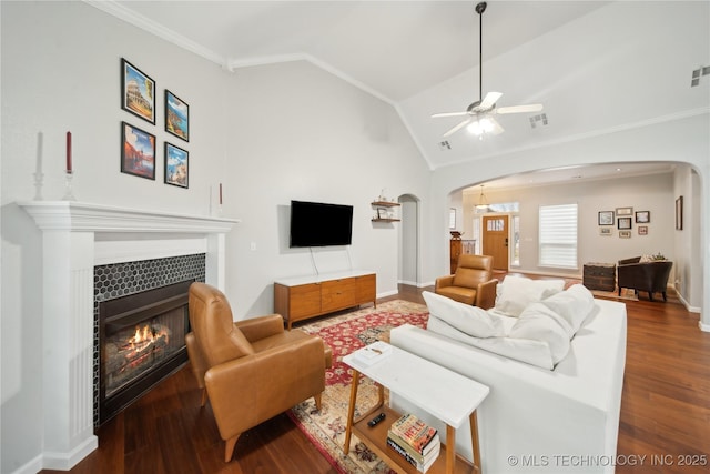 living room with a tile fireplace, ceiling fan, lofted ceiling, and hardwood / wood-style flooring