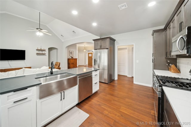 kitchen with appliances with stainless steel finishes, dark wood-type flooring, sink, white cabinetry, and lofted ceiling