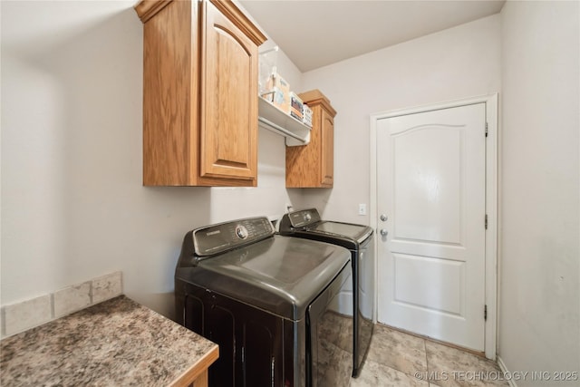 laundry room featuring cabinets and washer and clothes dryer