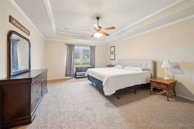 carpeted bedroom with ceiling fan, crown molding, and a tray ceiling