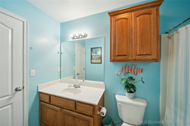 bathroom featuring vanity, curtained shower, and toilet