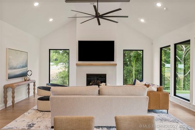 living room with ceiling fan, high vaulted ceiling, and light wood-type flooring