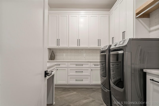 clothes washing area with tile patterned flooring, cabinets, and independent washer and dryer