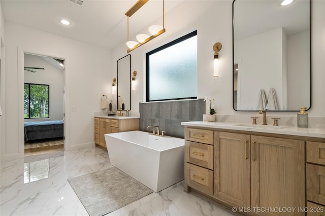 bathroom featuring vanity and a tub to relax in