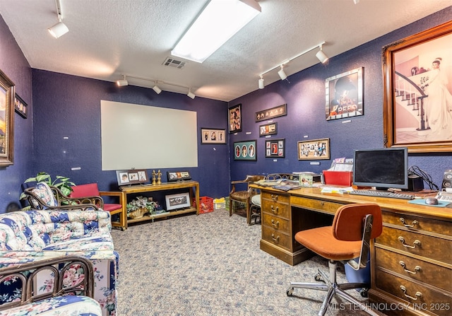 carpeted office space featuring rail lighting and a textured ceiling