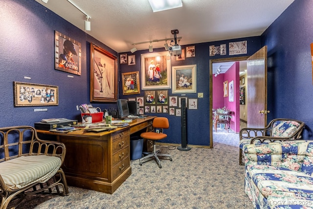 carpeted office space with a textured ceiling and track lighting