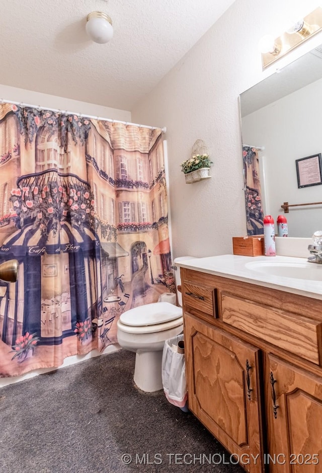 bathroom featuring vanity, a textured ceiling, and toilet