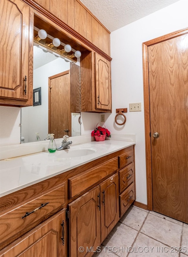 bathroom featuring vanity, a textured ceiling, tile patterned floors, and wooden walls