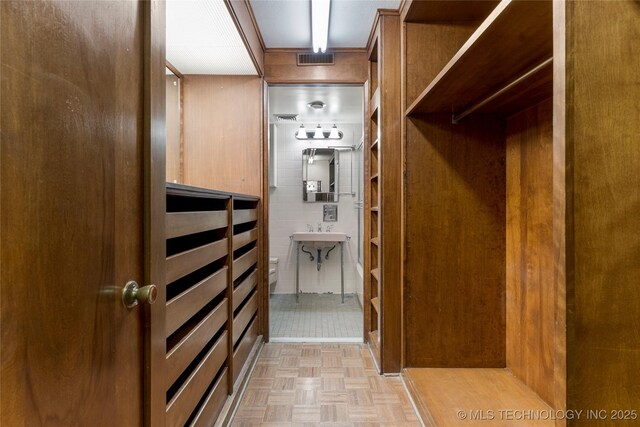 spacious closet featuring light parquet flooring