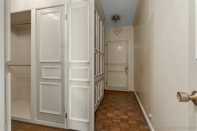 corridor with dark parquet flooring and crown molding