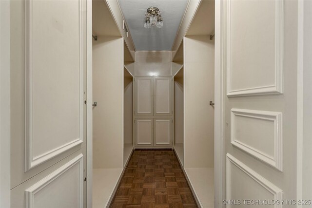 spacious closet with dark parquet floors