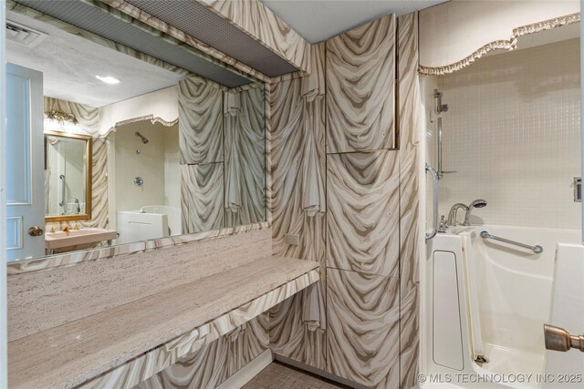 bathroom featuring a textured ceiling and a tub to relax in