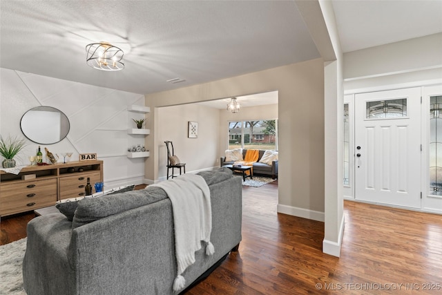 living room with dark hardwood / wood-style floors and a notable chandelier