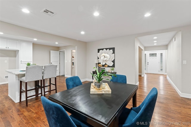 dining space with wood-type flooring