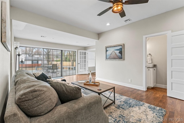 living room featuring ceiling fan and dark hardwood / wood-style flooring