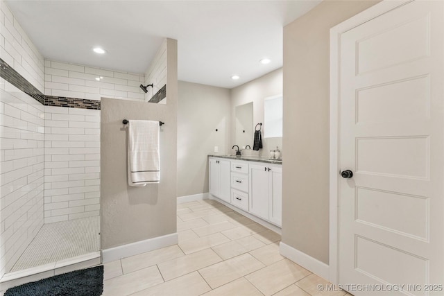 bathroom with tile patterned flooring, vanity, and tiled shower