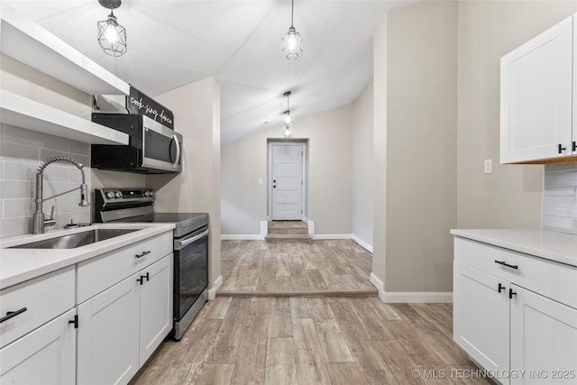 kitchen featuring pendant lighting, white cabinets, sink, tasteful backsplash, and stainless steel appliances