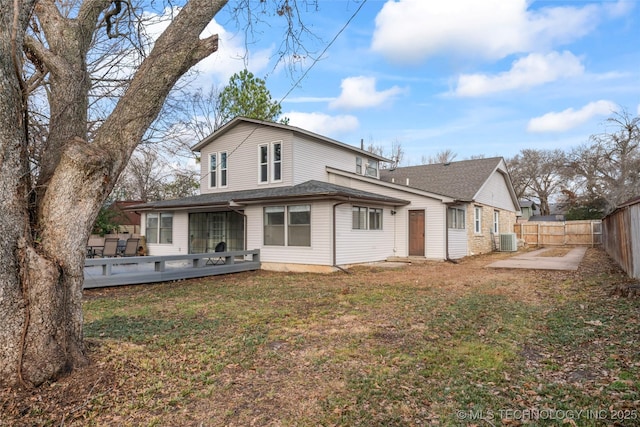 back of property featuring central AC, a deck, and a lawn